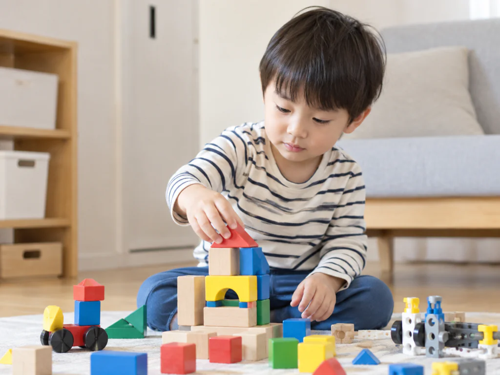 4歳のお子さまがブロックや組み立て系おもちゃで遊んでいる様子の写真