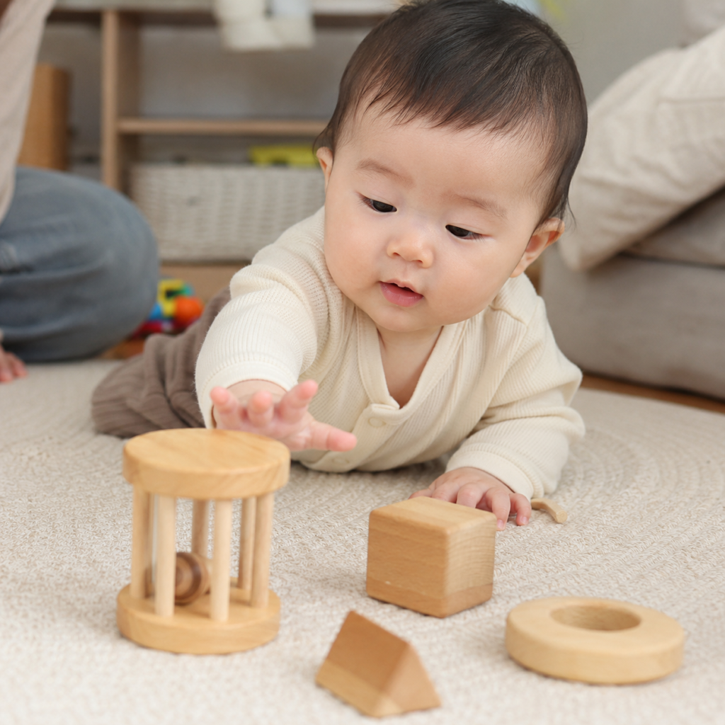 生後6〜8ヶ月頃の赤ちゃんが木製のおもちゃに手を伸ばして遊んでいる様子