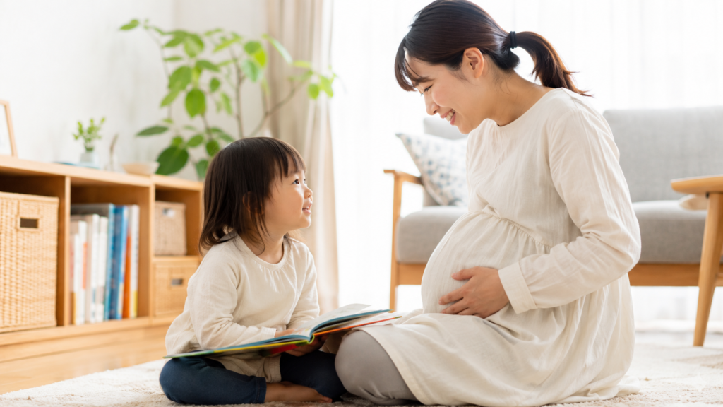 妊娠中のお母さまが上の子と穏やかに向き合っているイメージ写真